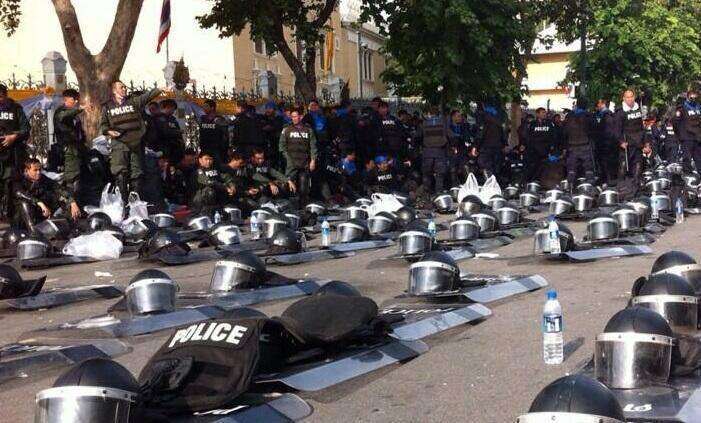 Riot police in Thailand put down their helmets and shields in solidarity with nonviolent activists campaigning for the removal of the corrupt Shinawatra government, 6 December 2013.